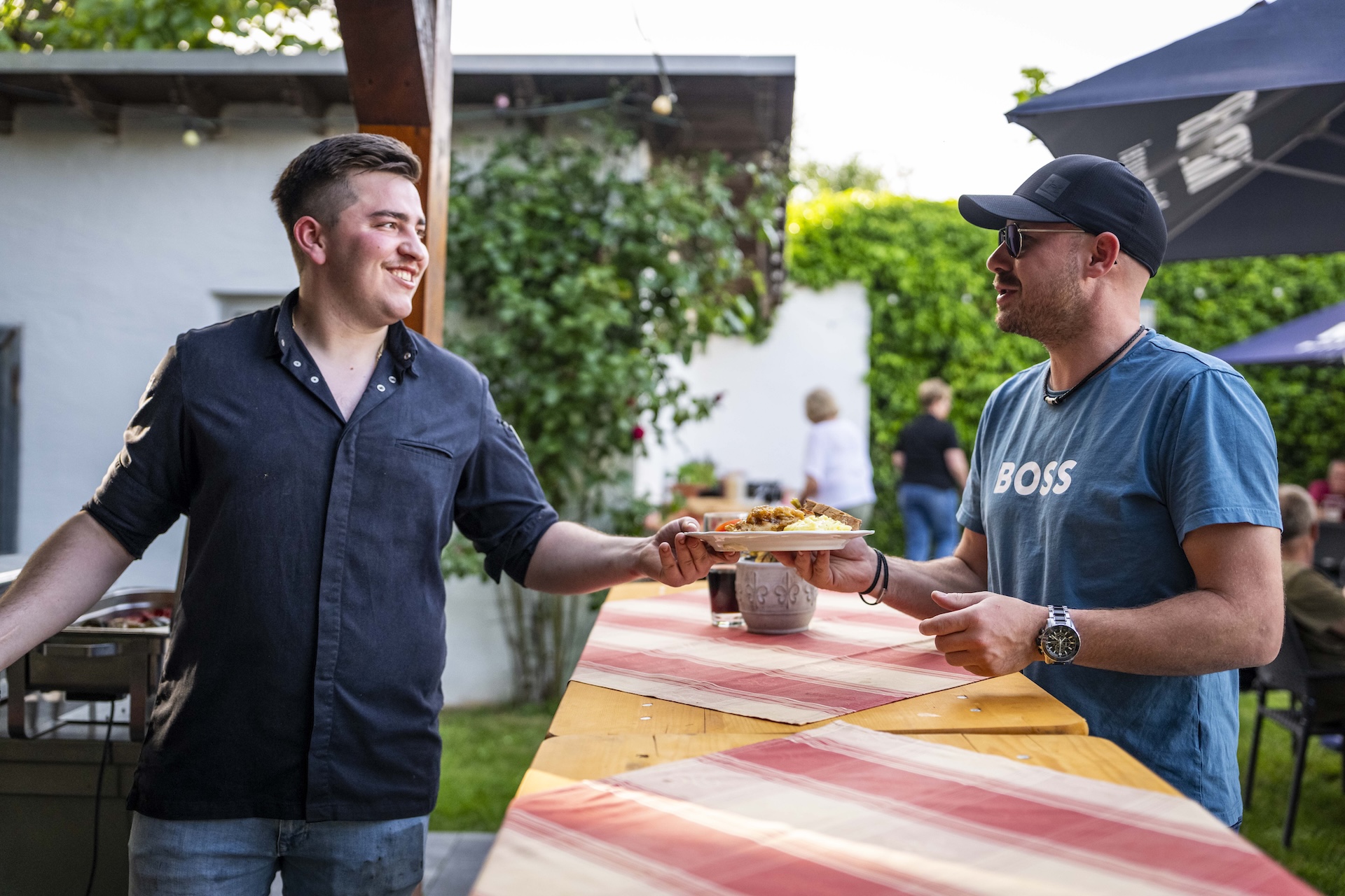 Moselhöhe - Freundlicher Koch überreicht einem Gast einen frischen Grillteller beim BBQ im Landgasthaus Moselhöhe